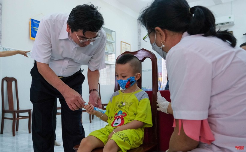 Ông Trần Thanh Bình, Giám đốc Sở GD&ĐT TP Cần Thơ tặng bánh kẹo động viên trẻ sau tiêm ngừa.