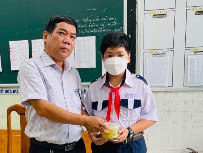 Thầy Lâm Ngọc Thành, Phó Hiệu trưởng Trường THCS Nguyễn Trãi (TP Long Xuyên, tỉnh An Giang) trao phần ăn sáng cho học sinh tại trường