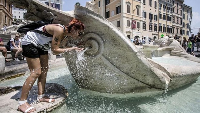 Một du khách đang hứng nước từ đài phun nước Barcaccia ở quảng trường Tây Ban Nha, trung tâm thủ đô Rome. (Nguồn: ANSA)