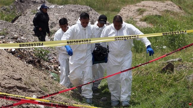 Cảnh sát Mexico mang thi thể từ một ngôi mộ tập thể