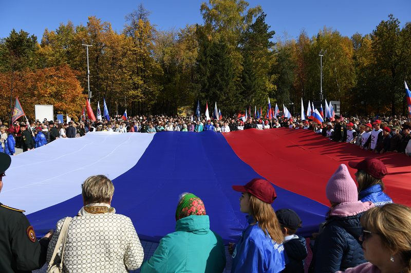 Mọi người cầm lá cờ Nga khổng lồ ủng hộ cuộc trưng cầu dân ý về việc gia nhập Nga của Cộng hòa Nhân dân Donetsk và Lugansk (DPR, LPR), cũng như các phần do Nga kiểm soát ở khu vực Zaporozhye và khu vực Kherson của Ukraine 