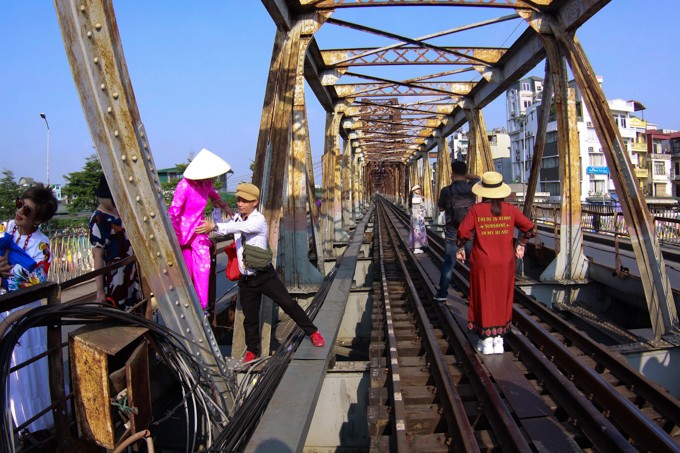 Người dân và khách du lịch thản nhiên vượt rào để vào khu vực đường ray trên cầu Long Biên.