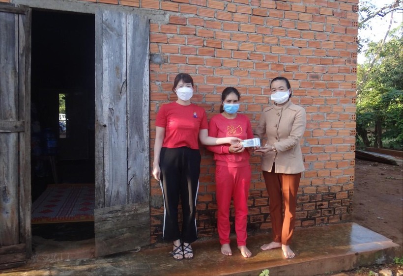 Cô Lê Thị Tân (bìa phải) trao tiền hỗ trợ cho gia đình em Y Qua Niê.