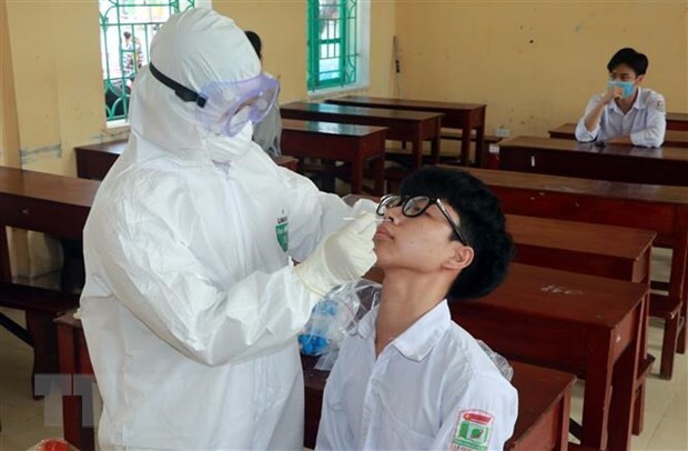 Lấy mẫu xét nghiệm Covid-19 cho học sinh ở Nam Định. (Nguồn: TTXVN)