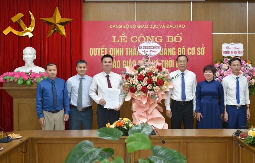 Thứ trưởng Phạm Ngọc Thưởng – Bí thư Đảng ủy Bộ GD&ĐT (thứ 3 từ phải qua trái) trao quyết định và tặng hoa chúc mừng tập thể Báo Giáo dục & Thời đại.