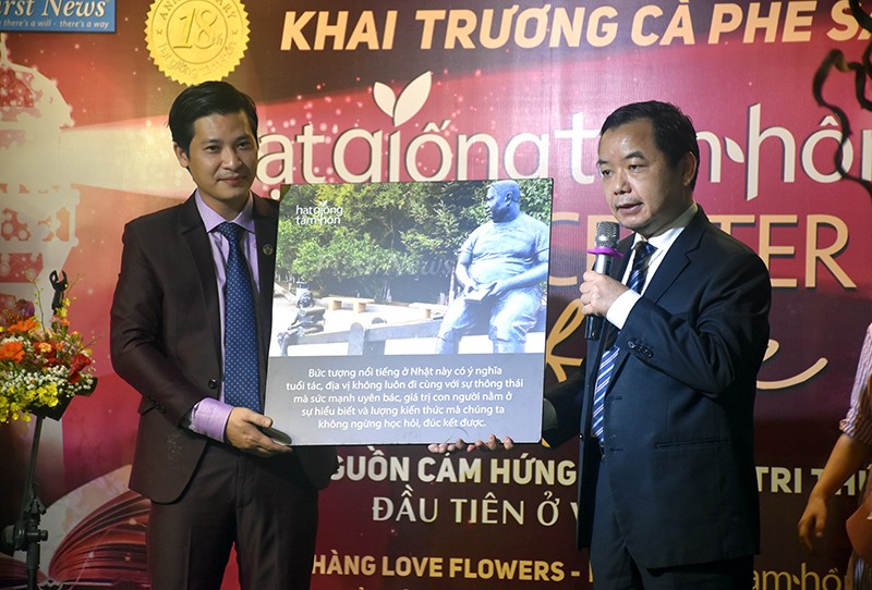 Ông Nguyễn Văn Phước (phải) tặng món quà ý nghĩa cho CEO Nguyễn Văn Huân, nhân dịp khai trương cà phê sách Hạt giống tâm hồn.