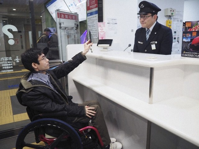 Người dùng xe lăn xuất trình ID Mirairo của mình tại ga Seibu Shinjuku Line Nakai ở Tokyo.