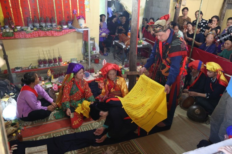 Thầy Tào (đứng) làm lễ cho bà bụt Lương Thị Mặn (người ngồi cầm quạt).