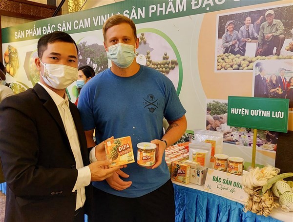Nguyễn Hữu Hạnh (ảnh trái) giới thiệu sản phẩm cho du khách quốc tế.