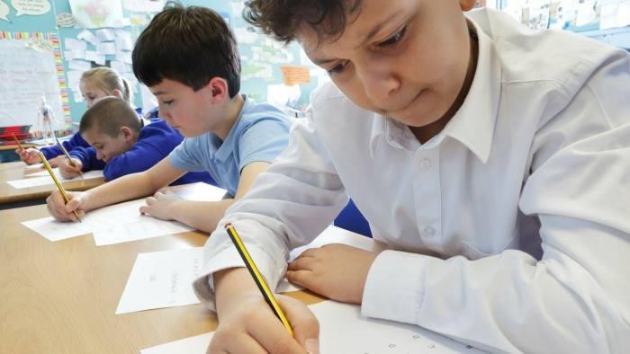 Học sinh tiểu học tại Anh luyện tập cách cầm bút.