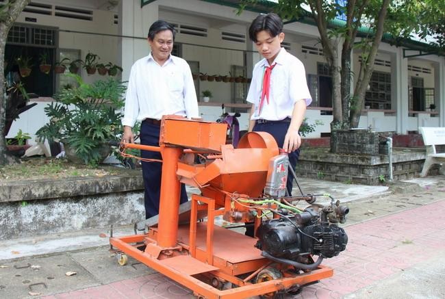 Nguyễn Thế Phong bên chiếc máy thu gom nông sản đa năng.