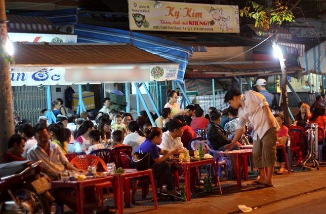Một quán nhậu bình dân ở quận 4, chật trong kín ngoài khách ngồi tràn ra tới mép đường. Ảnh: Zen Nguyễn.