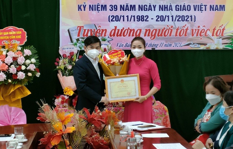 Thừa ủy quyền, ông Nguyễn Tân Sơn - Phó Chủ tịch UBND huyện Cẩm Khê trao Bằng khen của Bộ trưởng Bộ GD&ĐT cho cô giáo Chang.