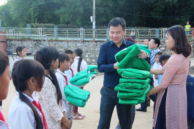 Nhà báo Triệu Ngọc Lâm, Tổng Biên tập Báo GD&TĐ trao tặng áo ấm cho học sinh Trường PTDTBT-THCS Tam Chung (Mường Lát, Thanh Hóa).