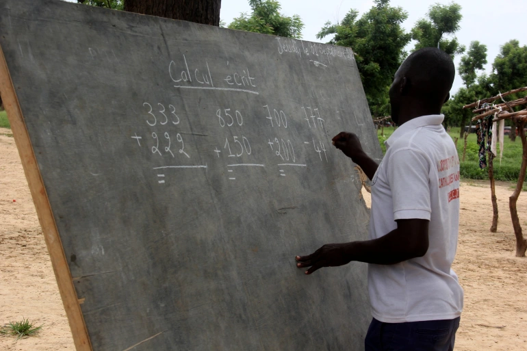 Thầy giáo Leonard Gamaigue dạy đang toán – một phần chương trình học di động tại trại du mục.