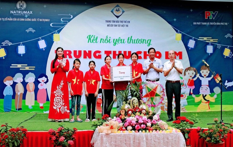 Lãnh đạo Trung tâm Bảo trợ trẻ em mồ côi tàn tật Việt Trì và nhà tài trợ tặng quà cho các em.