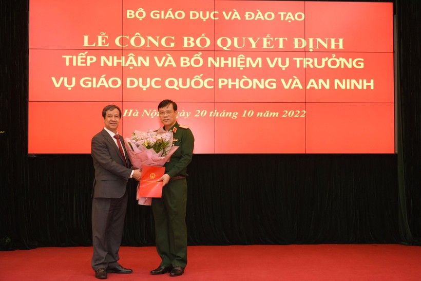 Bộ trưởng Bộ GD&ĐT Nguyễn Kim Sơn trao quyết định và tặng hoa chúc mừng Thiếu tướng Trần Ngọc Thanh.