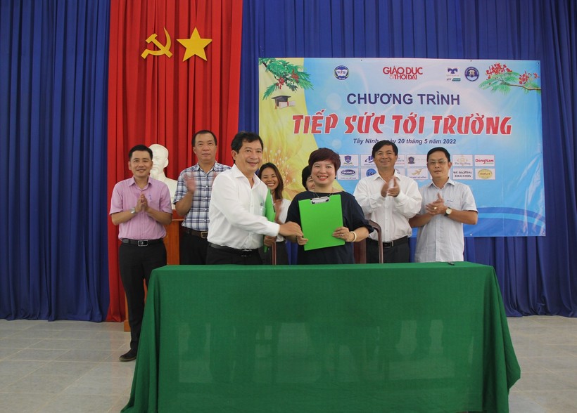 Nhà báo Dương Thanh Hương và ông Phạm Ngọc Hải trao văn bản ký kết.