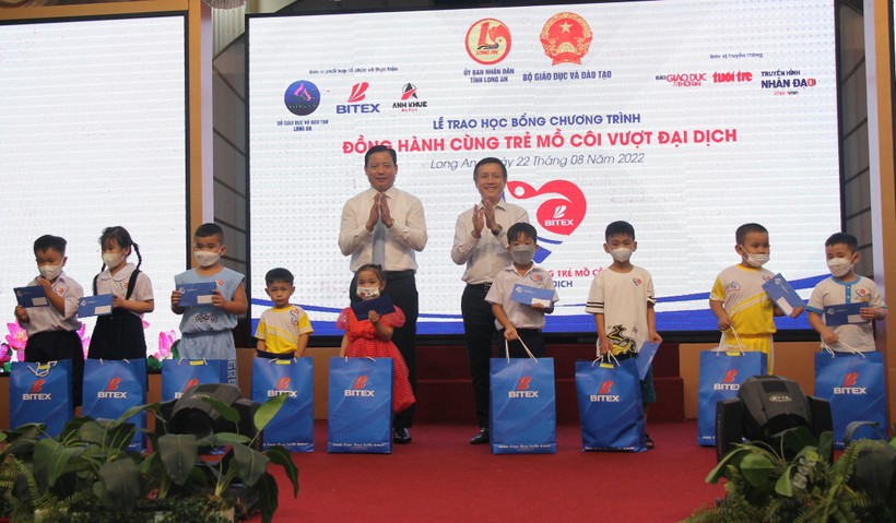 Ông Nguyễn Xuân Dũng và ông Phạm Tấn Hoà tặng học bổng cho các em học sinh.