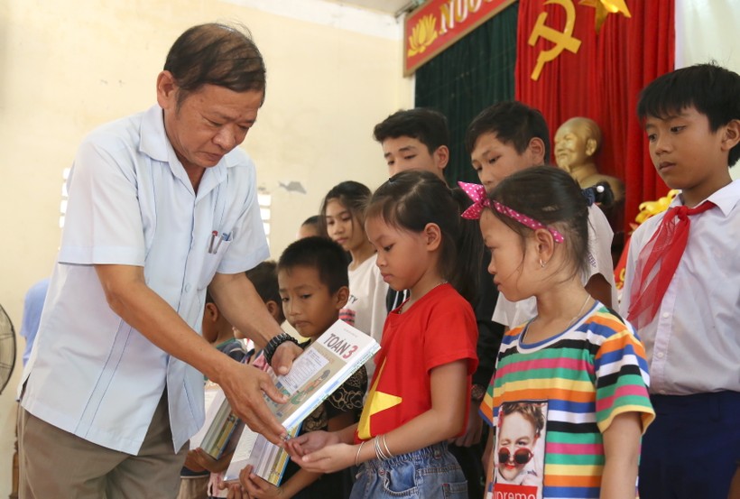 Ông Trần Lương Quang, Phó chủ tịch thường trực HĐND, chủ tịch Hội khuyến học huyện Gio Linh trao sách giáo khoa cho học sinh nghèo của huyện