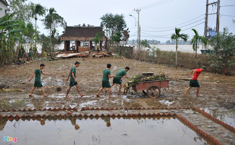 Các chiến sĩ của Tỉnh đội Quảng Bình đang dọn dẹp bùn đất, khắc phục ngôi nhà lưu niệm Đại tướng Võ Nguyên Giáp sau trận lũ. Ảnh: Zing.vn