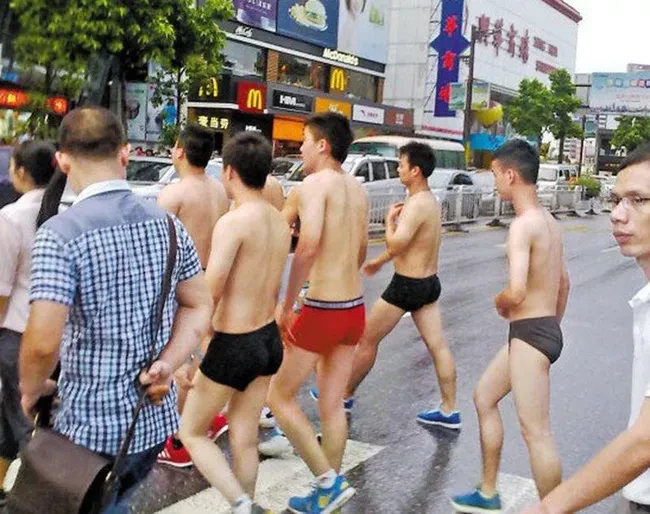 Nhóm nhân viên của một câu lạc bộ thể hình ở Phật Sơn (Quảng Đông) do không hoàn thành nhiệm vụ được đề ra trong ngày nên bị phạt phải mặc quần lót đi diễu hành trên phố. Ảnh chụp năm 2013