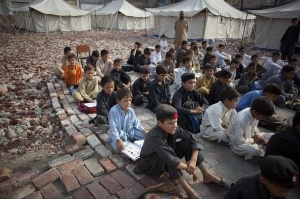 Trẻ em Afghanistan đang theo học một lớp học hỗn hợp tổ chức ngoài trời ngay trong trại tị nạn nằm trên biên giới Pakistan