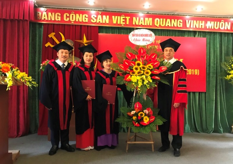 Viện trưởng PGS.TSKH. Nguyễn Minh Khởi nhận lẵng hoa chúc mừng từ các tân Tiến sĩ.